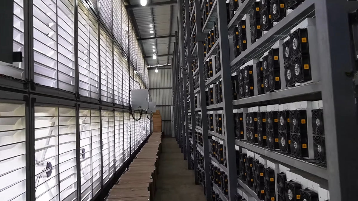 Hot room d'une ferme de minage : extracteurs d'air chaud face aux racks de mineurs